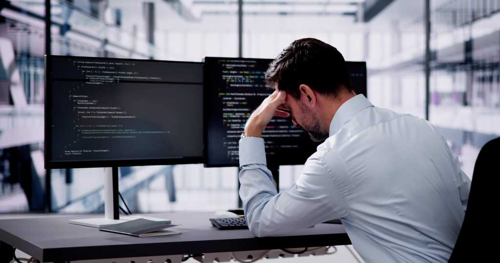 Unhappy Sad Developer Programmer Man In Stress Coding Software On Computer