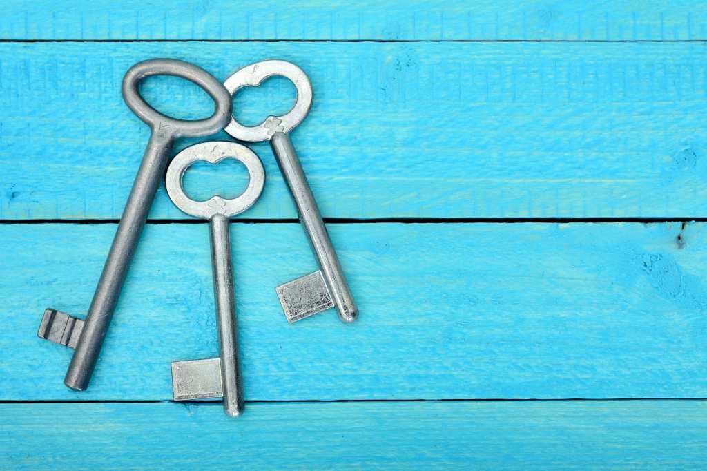Top view of three 3 keys on a wooden blue table