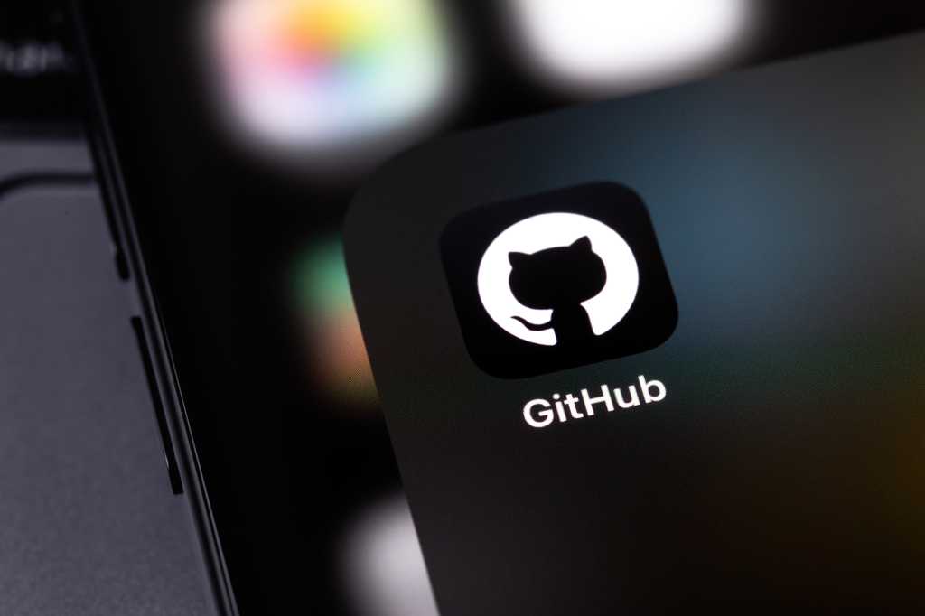 GitHub mobile icon app on a screen smartphone and notebook closeup. GitHub is the largest web service for hosting and developing IT projects. Batumi, Georgia - November 4, 2023